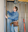 Insulated basement wall panels being placed against a concrete foundation wall in Eastchester